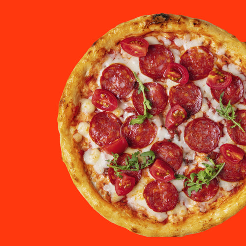 A delicious pepperoni pizza topped with slices of pepperoni, melted cheese, tomato pieces, and garnished with fresh greens, set against a bright orange background.